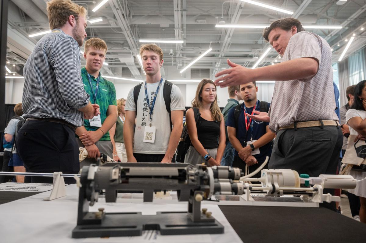 Students and attendees gather around a drone and equipment during a Georgia Tech technology demonstration.