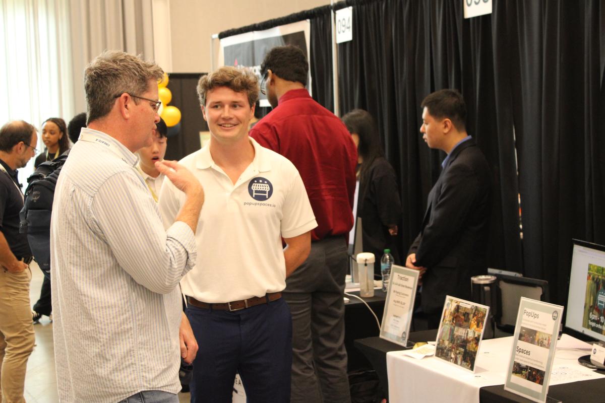 two men talkingnear a booth