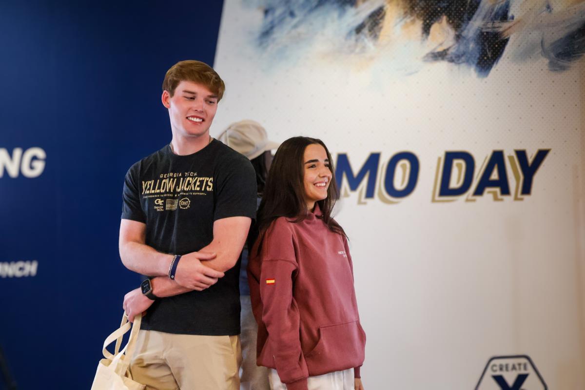 boy and girl standing near demo day sign